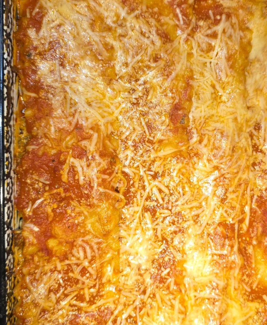 Homemade lasagna in a glass baking dish with golden melted cheese